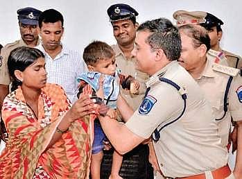 The toddler being handed over to his mother by the police on Saturday| Express