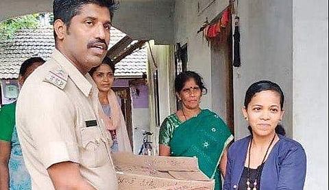 A member from Navu Hudugiyaru group hands over relief materials to police to be sent to  flood-affected areas in Ankola  | Express