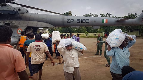 Jawans and villagers unload relief material food and other items from an Indian Air Force helicopter for the flood victims at Shirol taluka in Kolhapur Maharashtra Tuesday August 13 2019. | PTI