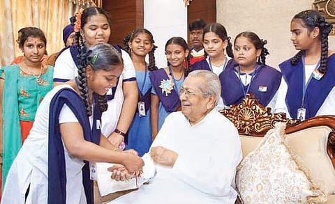 A student ties a rakhi to the Governor at the Raj Bhavan on Thursday (Photo |EPS)