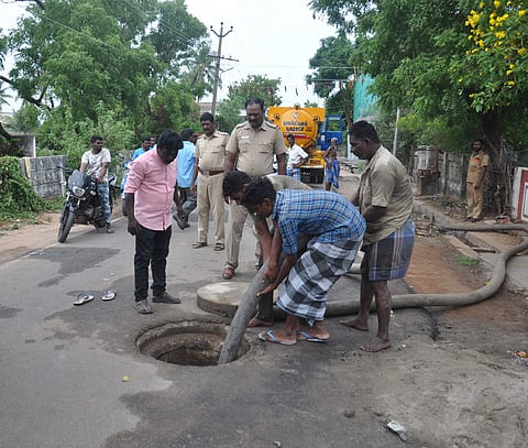 Workers pumping fresh water into the sewer to clear toxic gas built up inside before rescuing the trapped  workers. (Photo | EPS)