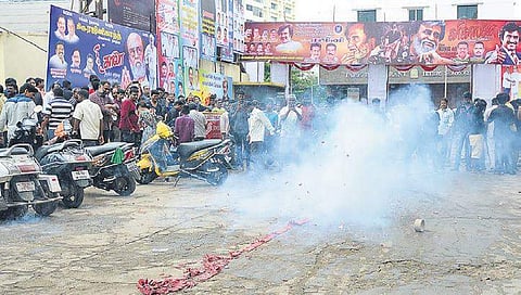 Fans burst crackers in front of a cinema theatre just before film star Rajnikanth’s Kalaa is shown on the first day of release | file