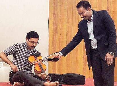 Vinod Haridas  playing violin at the press meet held in Kochi