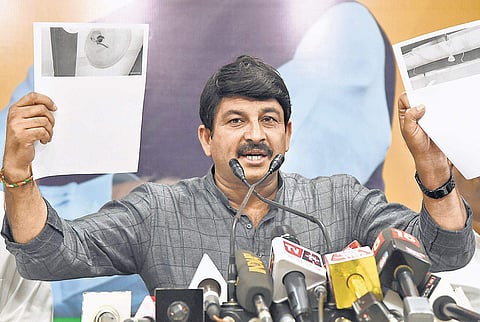 Delhi BJP chief Manoj Tiwari shows documents while addressing a press conference in New Delhi. (Photo | EPS, Parveen Negi)