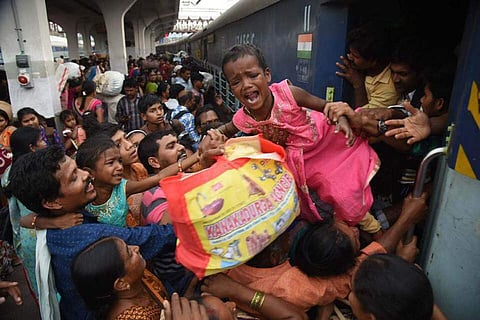 On World Photography Day, take a look at some of the best photographs by our lensmen. Each of them tells many stories - of contemporary India, of day-to-day struggles; a few are funny, some poignant... Enjoy! (IN PIC: A child being pulled out of a crowded