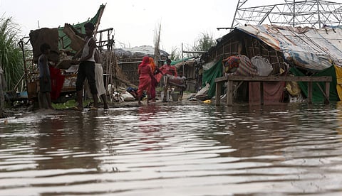 People are seen next to their half submerged makeshift house in the low-lying area near the banks of the Yamuna river in New Delhi on Monday August 19 2019.  | (Shekhar Yadav | EPS)