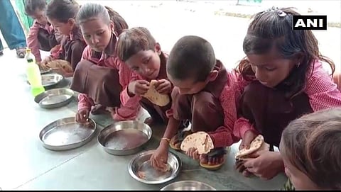 Students of a government primary school in Mirzapur district of Uttar Pradesh being served roti and salt under the mid-day meal scheme (Photo | ANI Twitter)