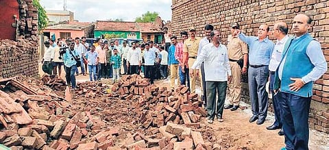 A villager shows his collapsed house to the Central team at Manjari village near Belagavi on Sunday | Express