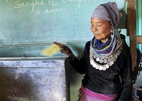 A Bru tribal woman casting her vote through postal ballot in Naisingpara Bru refugee relief camp. (File photo| PTI)
