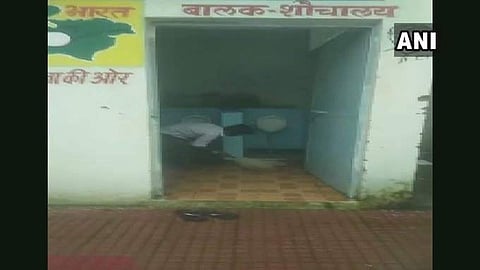 Students of a primary government school in Khandwa were seen cleaning toilet of their school in a viral video. (Photo | ANI Twitter)