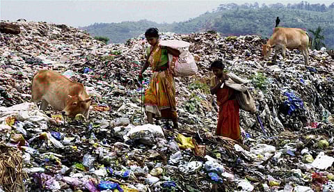 Rag pickers look for recyclable materials at a garbage dump site.