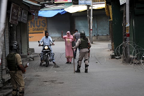 A Kashmir woman asks for permission to cross the road from a paramilitary soldier at a temporary check point during a restrictions in Srinagar, Friday, August 30, 2019. | AP 