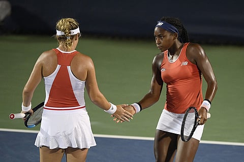 Coco Gauff, right, slaps hands with Catherine McNally, left, during a doubles match at Citi Open tennis tournament. (Photo | AP)
