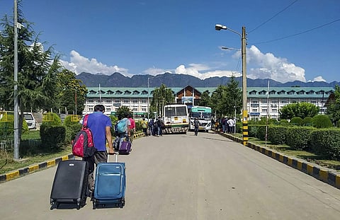 Non- local NIT students waits for vehicle as they leave from valley after government issued security advisory for tourists and Amarnath yartis to curtail their stay in Kashmir in Srinagar Saturday August 3 2019. | PTI