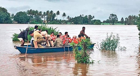 A group of villagers ferried to safer places on boats in Jamkhandi on Sunday
