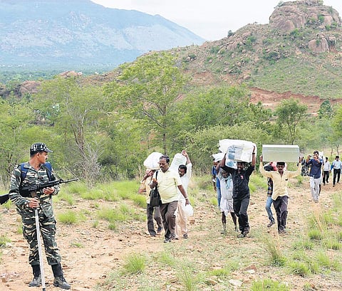 villagers carrying the EVMs and VVPATs uphill to Nekkanamalai on Sunday | Express