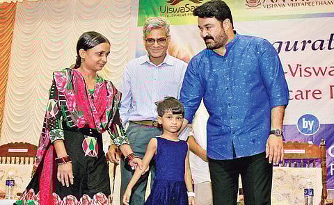 Actor Mohanlal welcomes five-year-old Simran along with her mother at a function held at AIMS on Monday | ARUN ANGELA