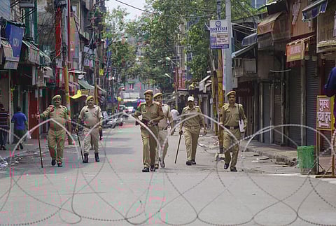 Policemen patrol a street during restrictions at Raghunath Bazar in Jammu. (Photo | PTI)