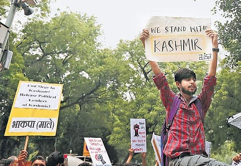 A Left party supporter holds up a placard, expressing solidarity with the people of Kashmir, during a protest against the Centre’s decision on Monday | arun kumar