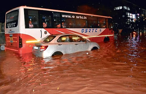 Vehicles pass through the flooded road in front of Iskcon Temple after a downpour in Bhubaneswar on Tuesday night (Photo | EPS)
