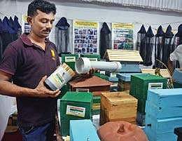 Binu P T explaining about his unique beehive at his stall;