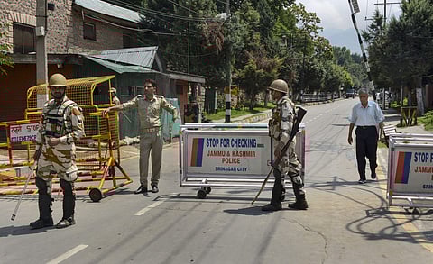 Security personnel stand guard as they block a road leading to the residence of Farooq Abdullah Omar Abdullah and Mehbooba Mufti during restrictions in Srinagar Thursday August 8 2019.  | PTI