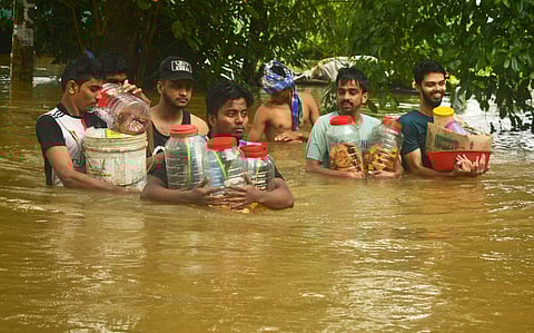 People evacuating their places in flood water in the heavy rain at Thengilakkadavu area in Kozhikode. (Photo | Manu R Mavelil, EPS)