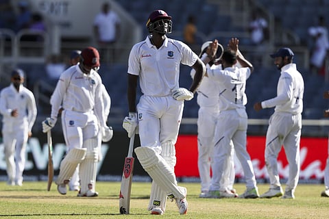 West Indies' captain Jason Holder looks up as players of India celebrate the dismissal of Shimron Hetmyer during day two of the second Test cricket match at Sabina Park cricket ground in Kingston, Jamaica. (Photo | AP)