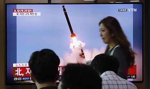 People watch a TV showing a file image of an unspecified North Korea's missile launch during a news program at the Seoul Railway Station. (Photo | AP)