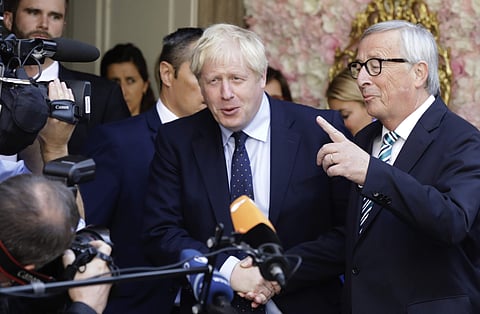 European Commission President Jean-Claude Juncker, right, speaks with the media as he shakes hands with British Prime Minister Boris Johnson prior to a meeting at a restaurant in Luxembourg, Monday. (Photo | AP)