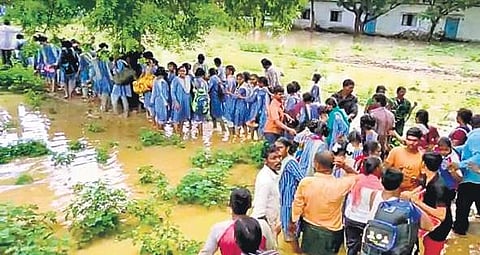 Students being rescued after the school inundated due to heavy rain in Allagadda  on Monday morning (Photo |EPS)