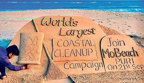 A sand sculpture of artiste Sudarshan Patnaik on coastal clean-up drive on Puri beach on Wednesday | Express