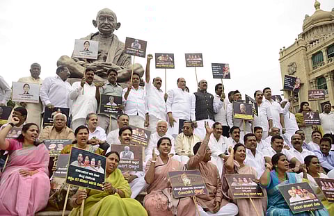 Congress members stage a protest against the Centre and state government over their ‘failure’ to provide relief material to the flood and drought-hit areas across the state, in Bengaluru on Wednesday | Shriram BN