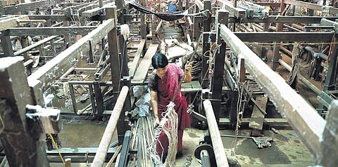 A worker engaged in cleaning the manufacturing unit of the Chendamangalam Handloom Weavers Cooperative Society in Kochi on Tuesday (Photo | Melton Antony)