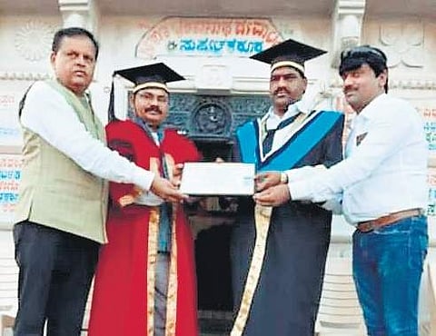 Mahadev (third from left) being presented with the doctorate.