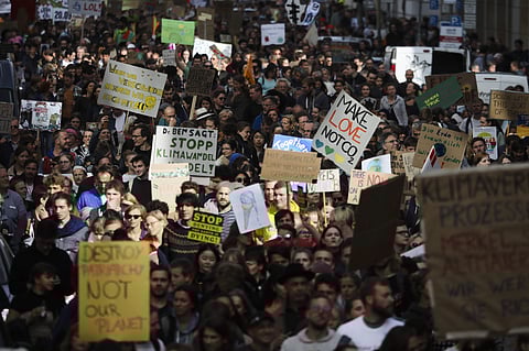 Demonstrators hold posters as they attend the 'Friday for Future' climate protest near the Brandenburg Gate in Berlin, Germany. (Photo | AP)