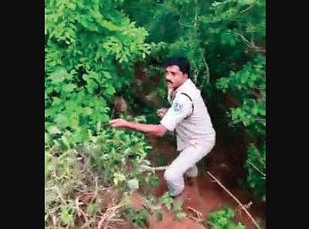 The policeman going  down the 150-feet deep abandoned well at Pedda Shapur village on Thursday (Photo |EPS)