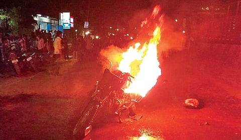 Villagers set a police vehicle on fire after a woman biker was injured in a road accident  which was caused due to a vehicle check conducted by police | Express