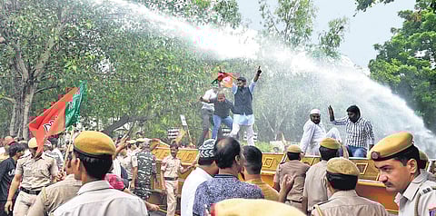 BJP workers stand on barricades as police use water cannons during a protest near the residence of CM Arvind Kejriwal over his remark against Manoj Tiwari, in New Delhi.| ( Photo | EPS )