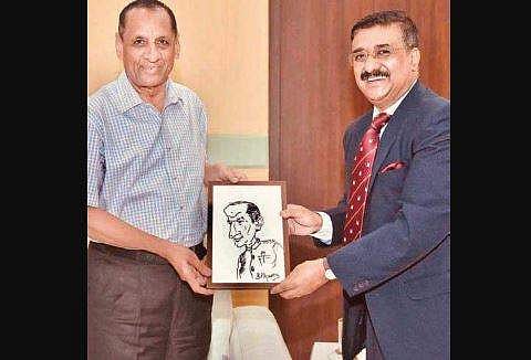 Senior bureaucrat BP Acharya presents outgoing Governor ESL Narasimhan with a caricature of him (Photo |EPS)