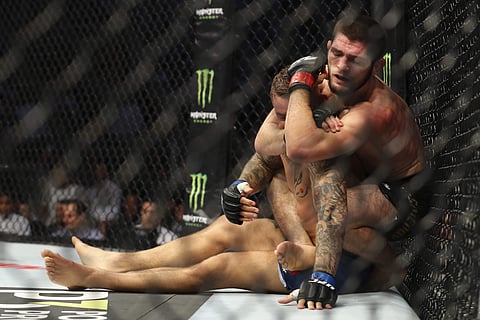Russian UFC fighter Khabib Nurmagomedov, choke holds UFC fighter Dustin Poirier, of Lafayette, La., during Lightweight title mixed martial arts bout at UFC 242. (Photo | AP)