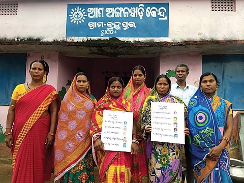 Members of MC and JC show information boards at Berhampur AWC in Angul. (Photo | Express)