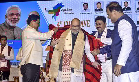 Home Minister Amit Shah being feliciated by Assam Chief Minister Sarbananda Sonowal during the 4th Conclave of the North East Democratic Alliance. (Photo| PTI)