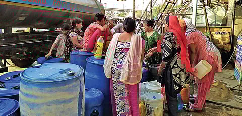 Residents in Harkesh Nagar fill buckets and drums with water from a Delhi Jal Board tanker (Photo | Somrita Ghosh)