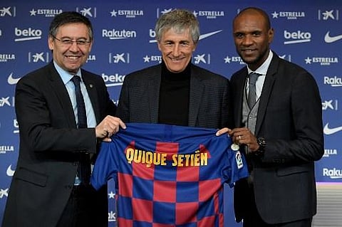 Barcelona FC president Josep Maria Bartomeu (L) and football director Eric Abidal (R) pose with new coach Quique Setien. (Photo | AFP)