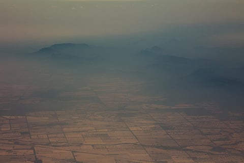 In this image released by the Australian Department of Defence and dated Jan. 7, 2019, smoke and haze hangs over mountains near Cooma, New South Wales from a No 11 Squadron P-8A Poseidon conducting damage assessment and surveillance in the bushfire affect