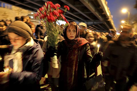 People gather for a candlelight vigil to remember the victims of the Ukraine plane crash, at the gate of Amri Kabir University that some of the victims of the crash were former students of, in Tehran, Iran. (Photo | AP)