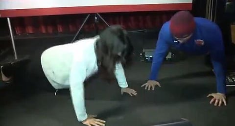 Tulsi Gabbard's Twitter feed on Friday shows a video of them going head to head for nine push-ups before the supporter rolls over in apparent defeat. (Photo | Twitter)