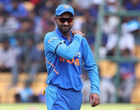 Shikhar Dhawan holds his shoulder as he leaves the ground after getting hurt while fielding during the Bengaluru ODI. (Photo | AP)