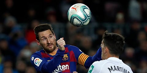 Barcelona's Lionel Messi, left, jumps for the ball with Granada's Jose Antonio Martinez during a Spanish La Liga soccer match between Barcelona and Granada at Camp Nou stadium in Barcelona. (Photo | AP)